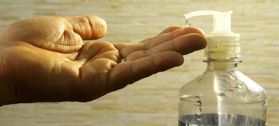 Fotografia de uma mão realizando higiene com álcool em gel 70%